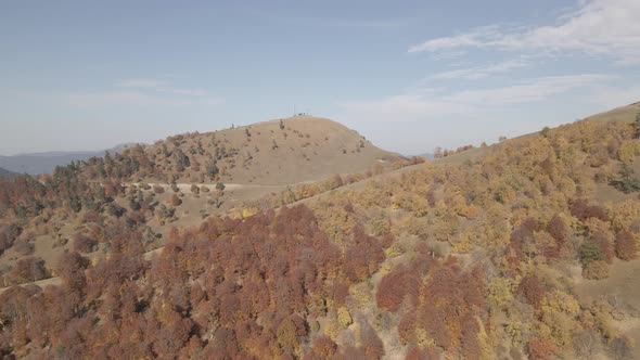 Flying over beautiful mountains in Bakuriani. Aerial view of Autumnal forest. Georgia alt