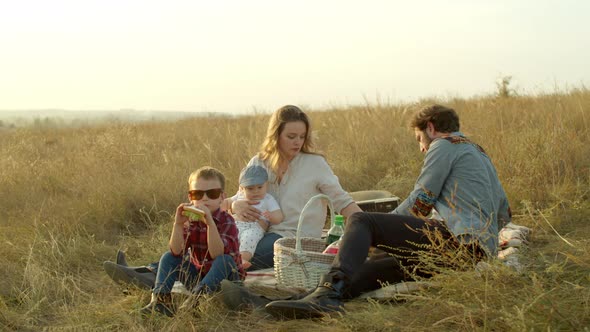 Happy Boy Playing with Parents During Picnic