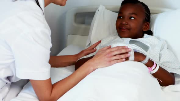 Female doctor consoling sick girl alt