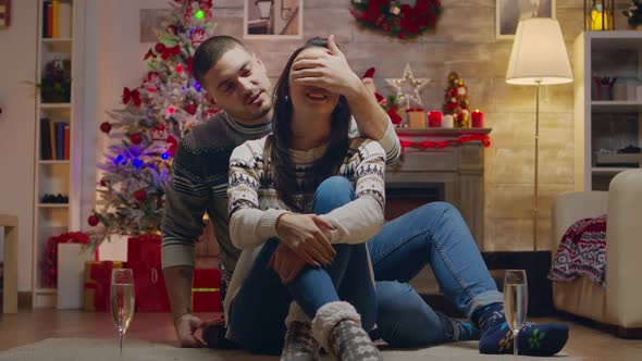 Husband Covering His Wife Eyes to Give Her a Surprise Gift alt