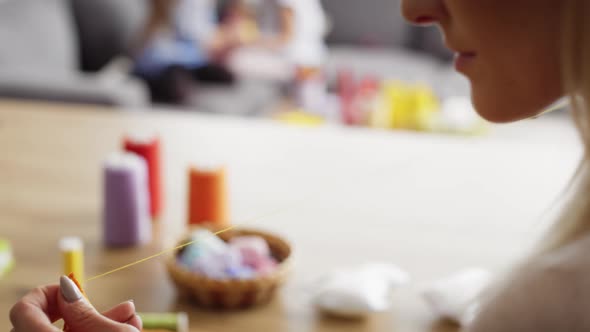 Detail video of woman sews at the table. Shot with RED helium camera in 8K alt