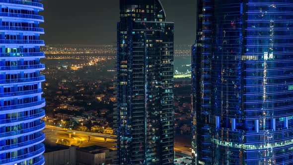Buildings of Jumeirah Lakes Towers with Traffic on the Road Aerial Night Timelapse alt