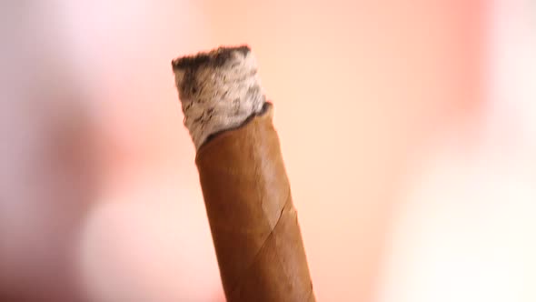 Extreme close up of someone holding and smoking a cigar in the Caribbean alt