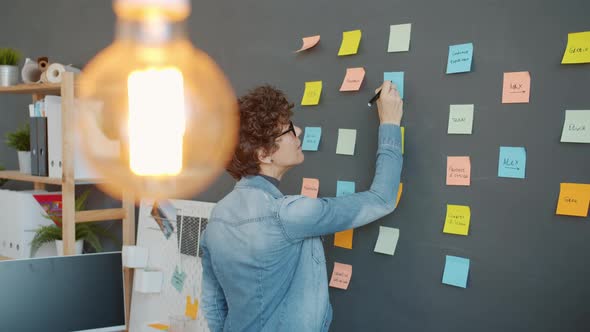 Slow Motion of Office Worker Writing on Bright Sticky Notes Planning Marketing Strategy in Workplace alt