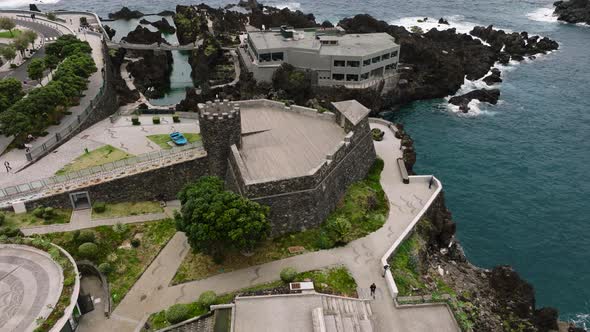 Aerial orbit around Madeira aquarium and view of Ilheu Mole; Porto Moniz alt