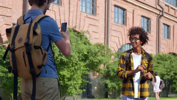 Caucasian Student Making Video of Afroamerican Friend Blogger Outdoors alt