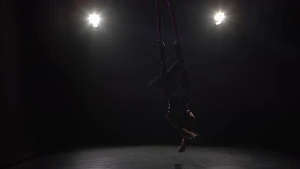 Girl Dancing with Aerial Silk Flying Wings in Black Background alt
