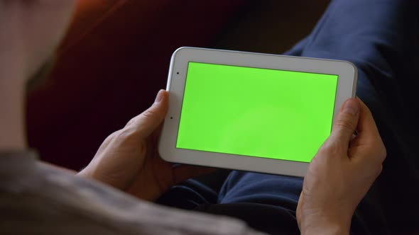 Man Sitting Using Blank Green Screen Tablet