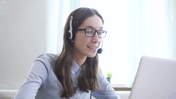 Young Woman Wearing Headphones Communicating Online Via Laptop Explaining Teaching alt