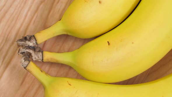 Bananas Laying On Maple Wood Cutting Board Spinning 03