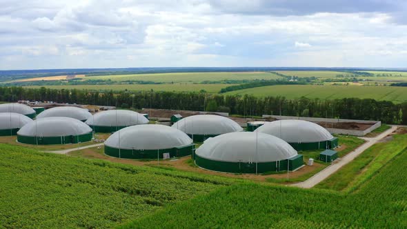 Round storage tanks for biogas. Biogas production on green landscape background.  alt