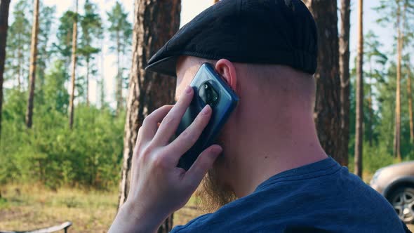 A Pensive Young Man in a Cap is Shown From the Side View alt