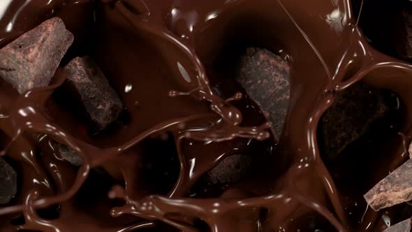 Super Slow Motion Shot of Raw Chocolate Chunks Falling Into Melted Chocolate at 1000 Fps alt