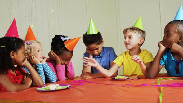 Boy interacting with his friends during birthday party alt
