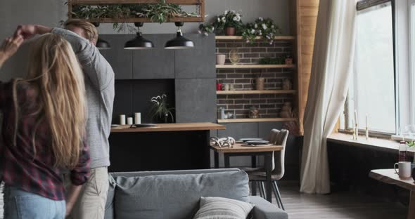 Cheerful Modern Marriage Couple Dancing Together Smiling Hugging to Each Other at Cozy Home alt