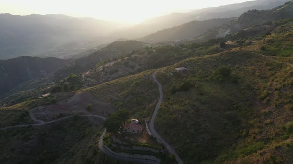 Revealing drone shot of the hillside homes in Castelmola in Sicily Italy during sun set, into the su alt