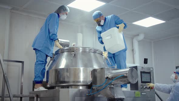 Pharmaceutical Workers in Protective Masks and Uniform Work with Medical Equipment at Medicine