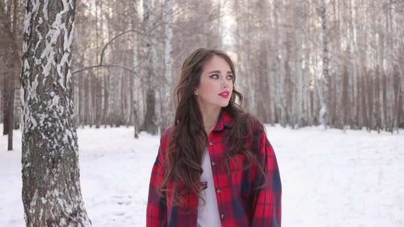 Charming Female with Long Hair Walking in Snowy Forest