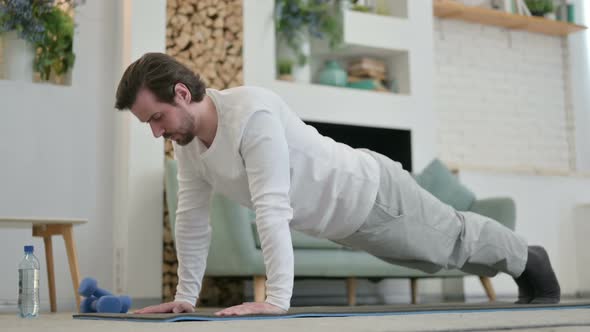 Young Man Doing Pushups on Yoga Mat at Home alt