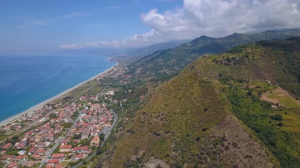 Aerial View of Hill Overlooking Sea Coast Village and Mountains. Flight Over Gorge, Sunny Day alt