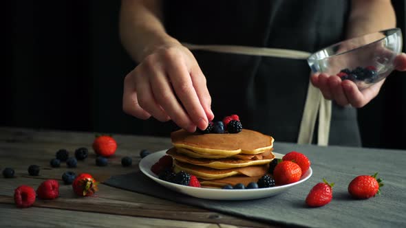 Female Hands Decorating Prepared with Their Own Hands Pancakes with Fruits and Berries