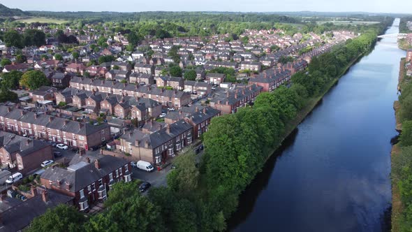Aerial view flying above wealthy Cheshire housing estate alongside Manchester ship canal slow descen alt