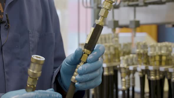 Professor Holding And Demonstrating Different Hydraulic Hoses Used In A Hydraulics Lab. - close up alt