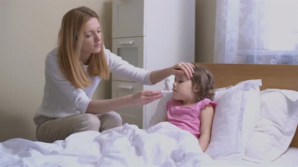 Mom is Measure the Temperature of Little Girl alt
