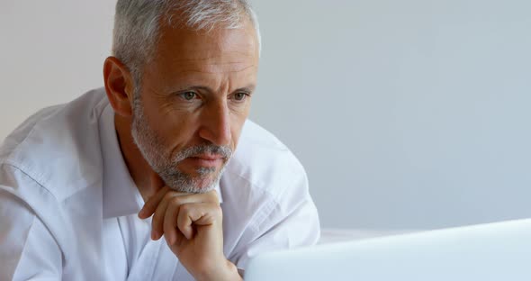 Businessman using laptop in hotel room alt