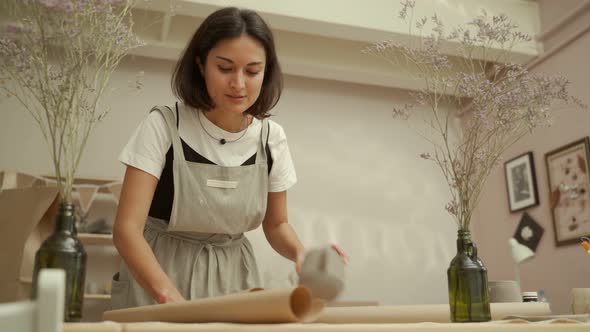 Artisan Wrapping Pottery in Paper