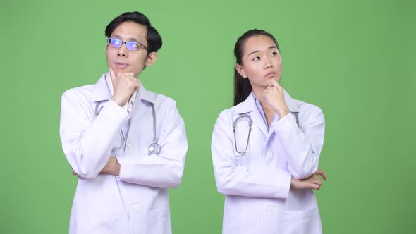 Young Asian Couple Doctors Thinking Together