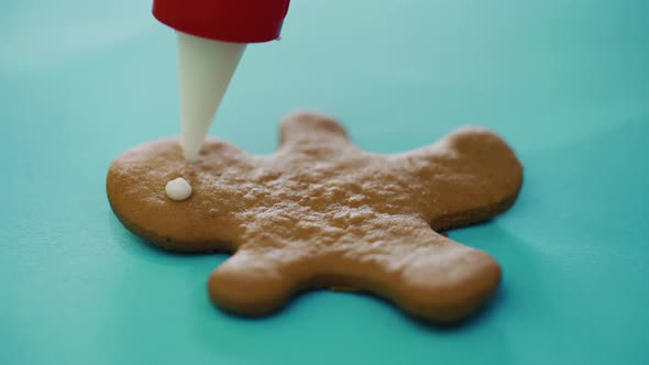Confectioner is Painting Cookies in the Form of a Ginger Man on the New Year  alt