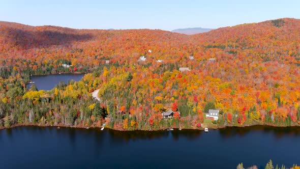 Aerial panoramic view of a lake and fall season foliage colors.