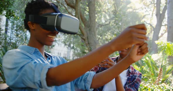 Twin sisters experiencing VR headset in the park 4k