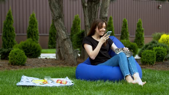 Young Woman Taking Photo with Kitten