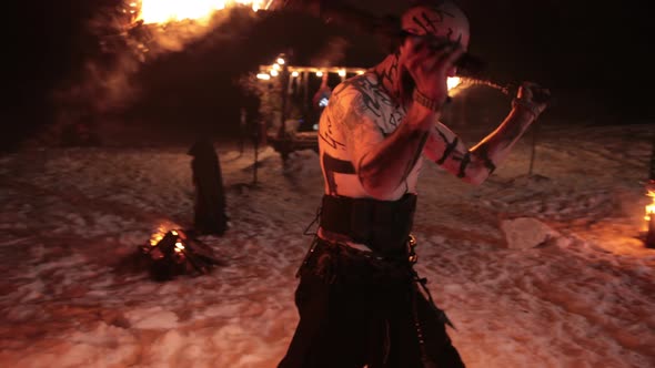 An Evil Aggressive Viking Warrior in Northern Tattoos with a Bare Torso Burning alt