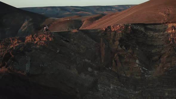 Drone View of Man on Motorbike Extremely Rides Across the Hills with Black Sea on Background 