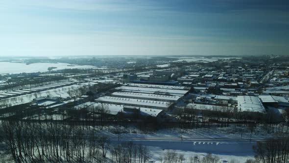 Factory Buildings Covered With Snow. Railway. In The Backlight Of The Setting Sun alt