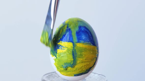 Closeup of a Person Painting Easter Eggs with a Special Brush alt