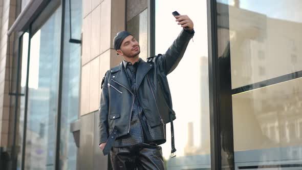 Portrait of Confident Caucasian Gay Man Taking Selfie on Smartphone Standing on City Street Outdoors alt
