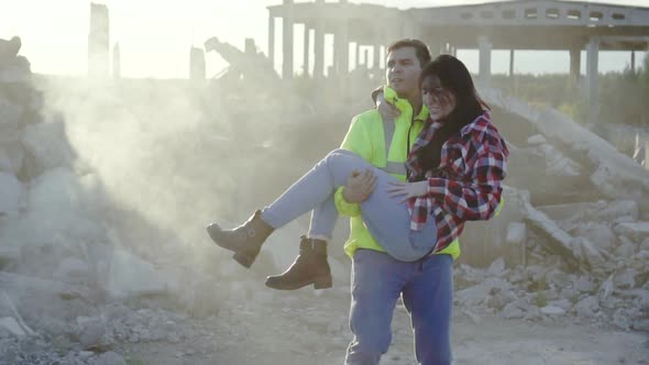 Man Rescue Worker in a Uniform Is on the Hands of the Earthquake Victim alt
