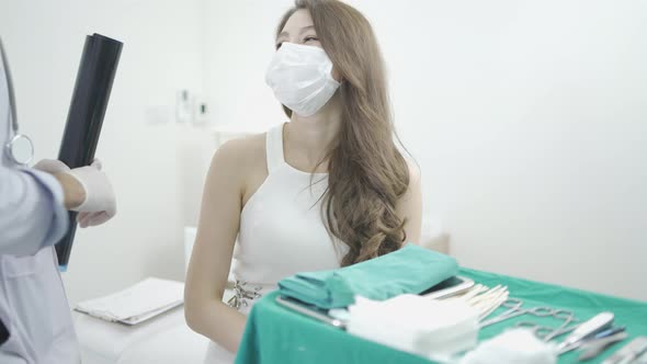 Male plastic doctor surgeon examining patients face for plastic surgery with facial x-ray film.
