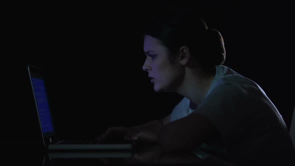 Teenager Girl Crying Because of Problems With Laptop, Sitting in Dark Room alt