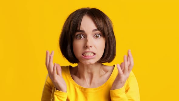 Shocked Young Woman Touching Head Worrying And Panicking Yellow Background alt