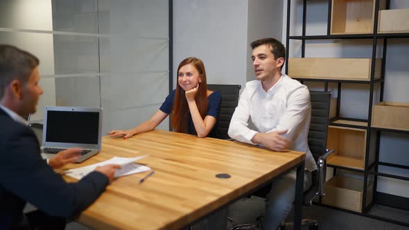 The Man and His Wife Speaking with Lawyer in Boardroom alt
