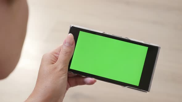 Young woman holds greenscreen  smart phone 4K 2160p 30fps UltraHD footage -  Green screen tablet dis