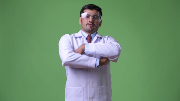 Young Handsome Persian Man Doctor Wearing Protective Glasses with Arms Crossed