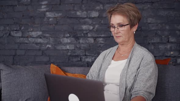 Matured Woman Spending Free Time with Laptop at House