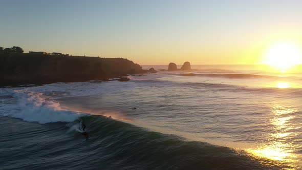 Aerial Shot: Epic Sunset surf in Punta de Lobos, pichilemu, chile. Surfer in the perfect Wave. alt
