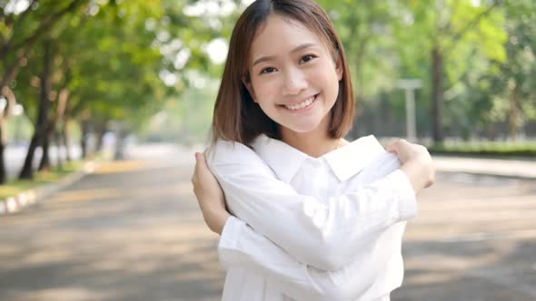 Beautiful Asian girl embracing herself Feeling at ease and caring, head tilted,no makeup
